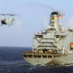 A CH-46 Sea Knight helicopter flies toward USNS Tippecanoe (T-AOE-199) And my job is on the flight deckg