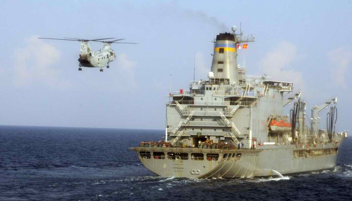 A CH-46 Sea Knight helicopter flies toward USNS Tippecanoe (T-AOE-199) And my job is on the flight deckg